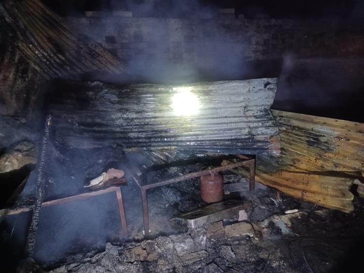 झोपड़ी से निकलती आग की लपटें व जला सामान।