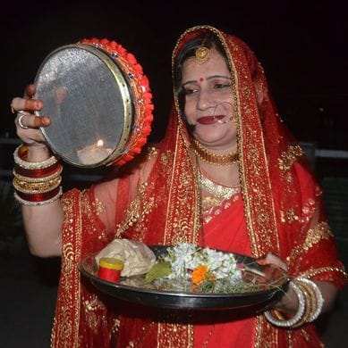 करवाचौथ पर पत्नी सौम्या को जल पिलाकर व्रत खुलवाते एडीएम एफआर अरविंद कुमार। स्रोत: स्वयं