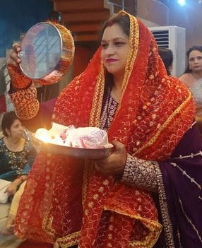 करवाचौथ पर पत्नी सौम्या को जल पिलाकर व्रत खुलवाते एडीएम एफआर अरविंद कुमार। स्रोत: स्वयं