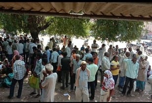 मंडी समिति में खाद केंद्र के बाहर खड़े किसान। संवाद मंडी समिति में खाद केंद्र के बाहर खड़े किसान। संवाद