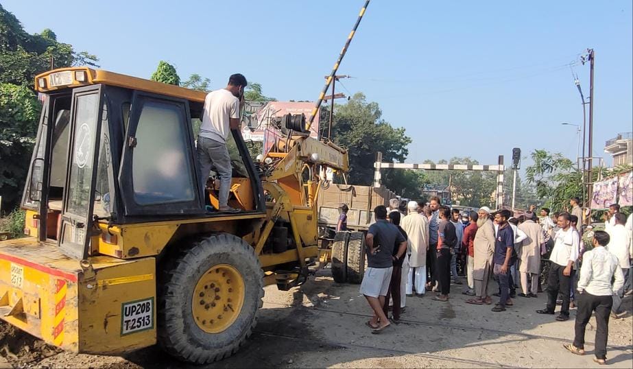 नगीना में कोतवाली मार्ग पर स्थित रेलवे फाटक के बीच ट्रैक पर फंसी रेत से भरी ट्रैक्टर ट्राली। सं
