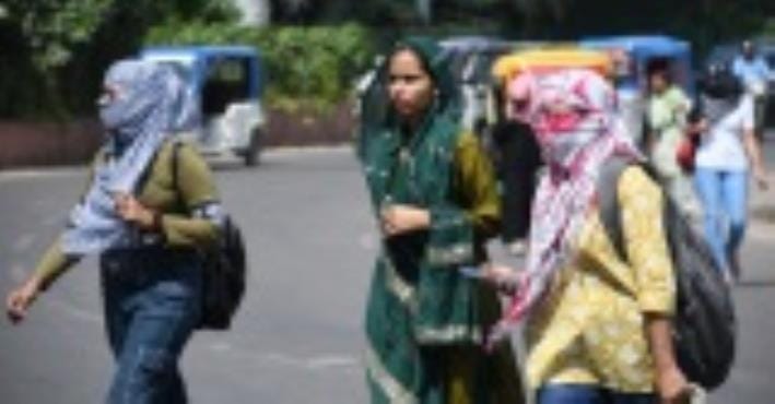 रविवार दोपहर धूप से बचतीं युवतियां। 