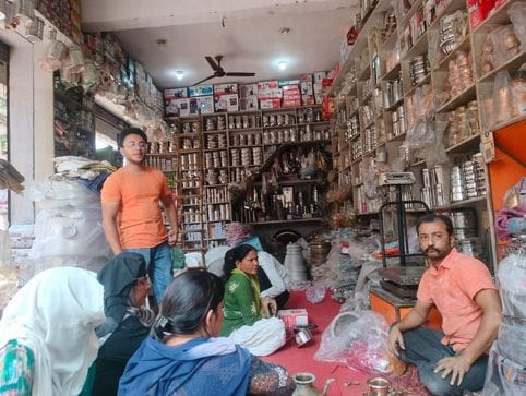 फूलों आदि की झालरों की सजी दुकान। संवाद