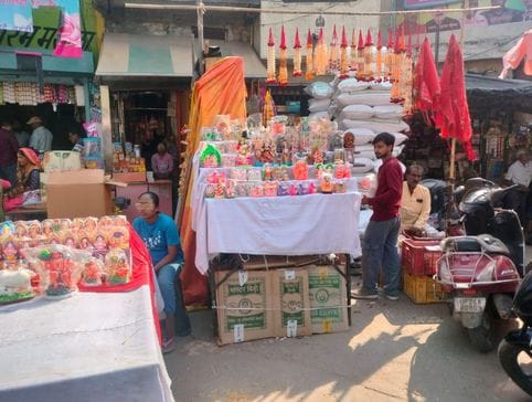 फूलों आदि की झालरों की सजी दुकान। संवाद