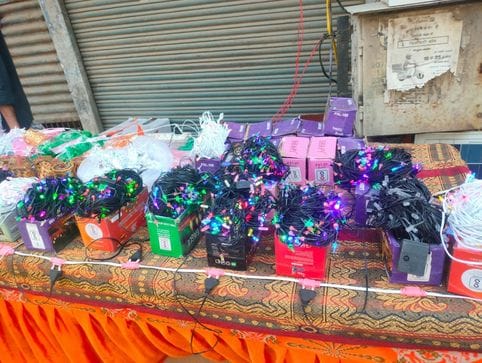 फूलों आदि की झालरों की सजी दुकान। संवाद