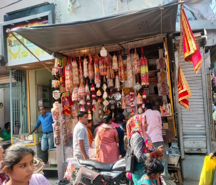 फूलों आदि की झालरों की सजी दुकान। संवाद