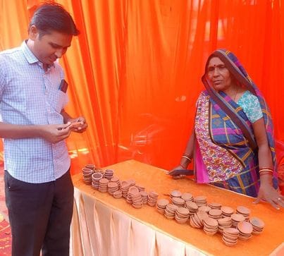 12 सीकेटीपी-1- परिचय-दिवाली मेले में बाजार में बेचने के लिए मिट्टी के दिए बनाती महिला । संवाद