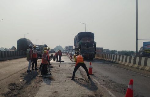 फोटो-20-दोस्तीनगर बाईपास में क्षतिग्रस्त स्थान पर बालू बिछाकर सड़क को बराबर करता रोड रोलर व निक