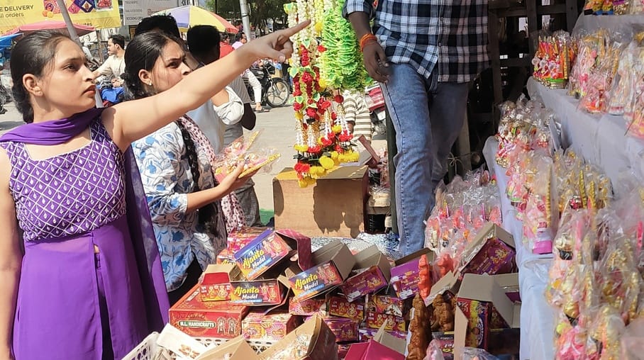 खीरी रोड पर सजी बाजार से लक्ष्मी गणेश की मूर्तियां खरीदती महिलाएं। संवाद