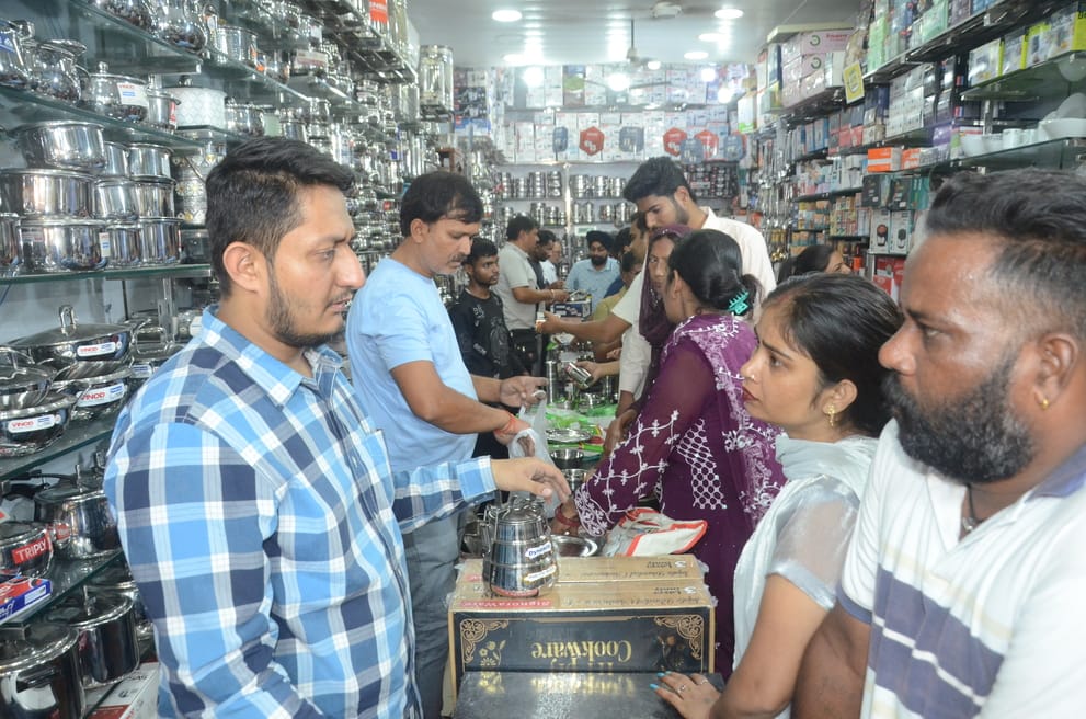 धनतेरस पर छावनी के बर्तन बाजार में बर्तन की खरीदारी करती महिला थाली में अपना चेहरा देखते हुए। फ धनतेरस पर छावनी के बर्तन बाजार में बर्तन की खरीदारी करती महिला थाली में अपना चेहरा देखते हुए। फ