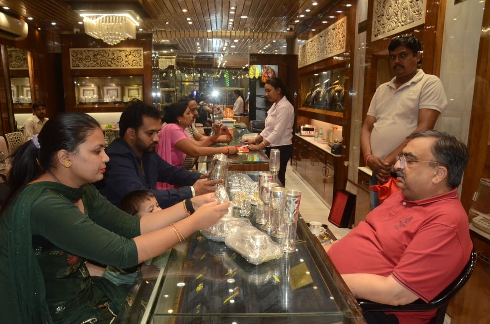धनतेरस पर छावनी के बर्तन बाजार में बर्तन की खरीदारी करती महिला थाली में अपना चेहरा देखते हुए। फ धनतेरस पर छावनी के बर्तन बाजार में बर्तन की खरीदारी करती महिला थाली में अपना चेहरा देखते हुए। फ