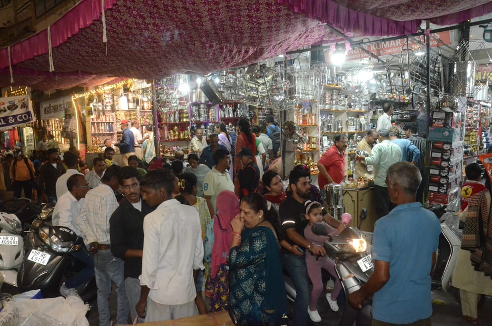 धनतेरस पर छावनी के बर्तन बाजार में बर्तन की खरीदारी करती महिला थाली में अपना चेहरा देखते हुए। फ धनतेरस पर छावनी के बर्तन बाजार में बर्तन की खरीदारी करती महिला थाली में अपना चेहरा देखते हुए। फ