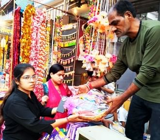 बहादुरगंज बाजार में कमलगट्टा और फूलों की खरीदारी करतीं महिलाएं। संवाद