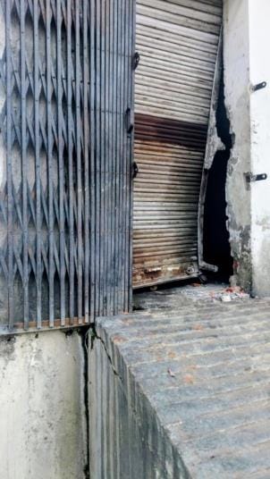 निगोहां में शोरूम में चोरी के बाद मौके की जांच करती पुलिस व टूटा पड़ा शटर और ताला।