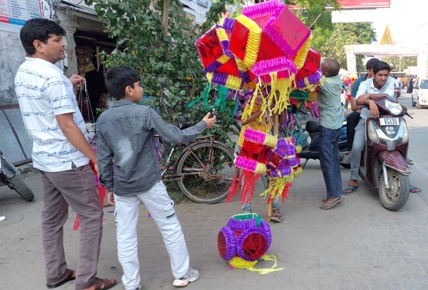 बिजनौर में दीपावली के लिए गणेश जी की मूर्ति पसंद करती युवती। संवाद