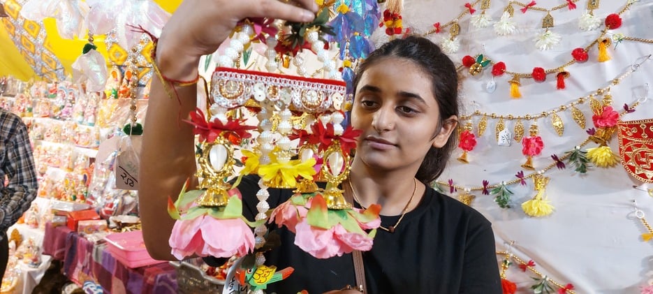बिजनौर में दीपावली के लिए गणेश जी की मूर्ति पसंद करती युवती। संवाद