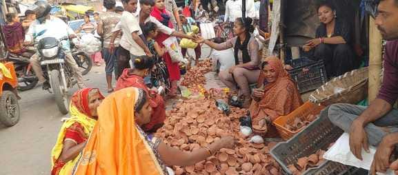 फोटो-25, दुकान पर माता लक्ष्मी की मूर्ति देखती महिला। संवाद