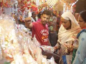 फोटो-25, दुकान पर माता लक्ष्मी की मूर्ति देखती महिला। संवाद