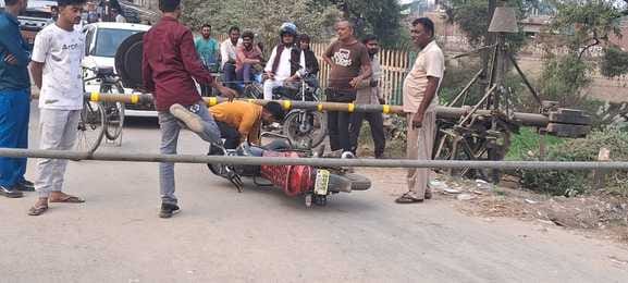 रेलवे बूम के नीचे से बाइक निकालते हुए रेलवे बूम के नीचे से बाइक निकालते हुए