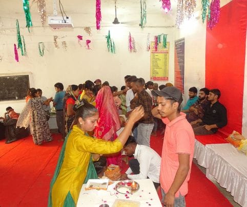 जेल में भाई को मीठा खिलातीं बहनें। संवाद