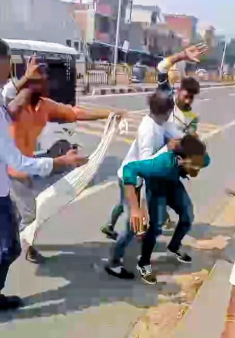 शिकायत करने निगोहां थाने जा रहे युवक को पीटते आरोपी।