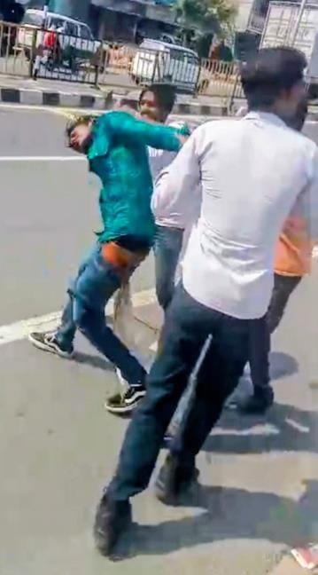 शिकायत करने निगोहां थाने जा रहे युवक को पीटते आरोपी।