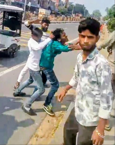 शिकायत करने निगोहां थाने जा रहे युवक को पीटते आरोपी।
