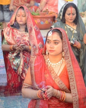 छठपर्व पर डूबते सूर्य को अर्घ्य देने के दौरान पूजा करती महिला। संवाद