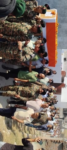 शहीद के बेटे को राष्ट्रीय ध्वज सौंपते कर्नल अनिल कुमार