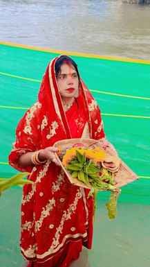शाहजहांपुर में खन्नौत नदी तट पर पानी में खड़े होकर सूरज की पूजा करती महिला। संवाद