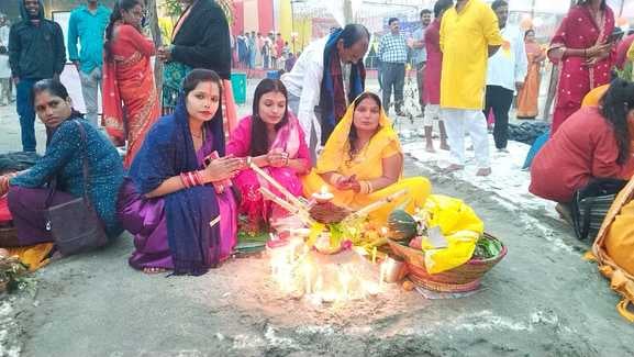 शाहजहांपुर में खन्नौत नदी तट पर पानी में खड़े होकर सूरज की पूजा करती महिला। संवाद