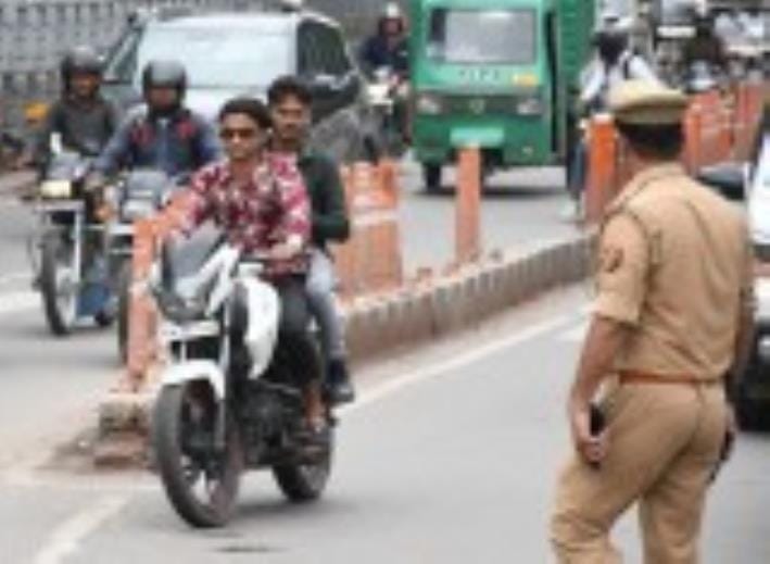 बिना हेलमेट व ट्रिपलिंग कर बाइक चलाते लोग। बिना हेलमेट व ट्रिपलिंग कर बाइक चलाते लोग।