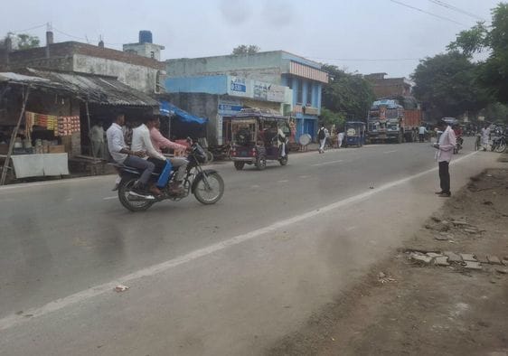तीन सवारी बिना हेलमेट बाइक सवार।  किसी का डर नहीं। संवाद