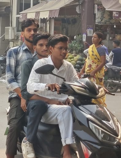 संकटा देवी पुलिस चौकी का ठीक सामने तीन सवारी बिना हेलमेट जाते लोग। संवाद