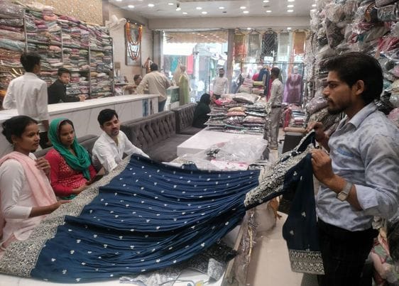 शहर के बड़े बाजार में कपड़े की दुकान पर लहंगा दखिाते दुकानदार । संवाद शहर के बड़े बाजार में कपड़े की दुकान पर लहंगा दखिाते दुकानदार । संवाद