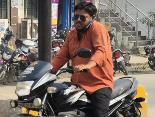 आंबेडकर पार्क के पास परिवार को बैठकर हेलमेट हैंडल में टांगकर जाते बाइक सवार। संवाद