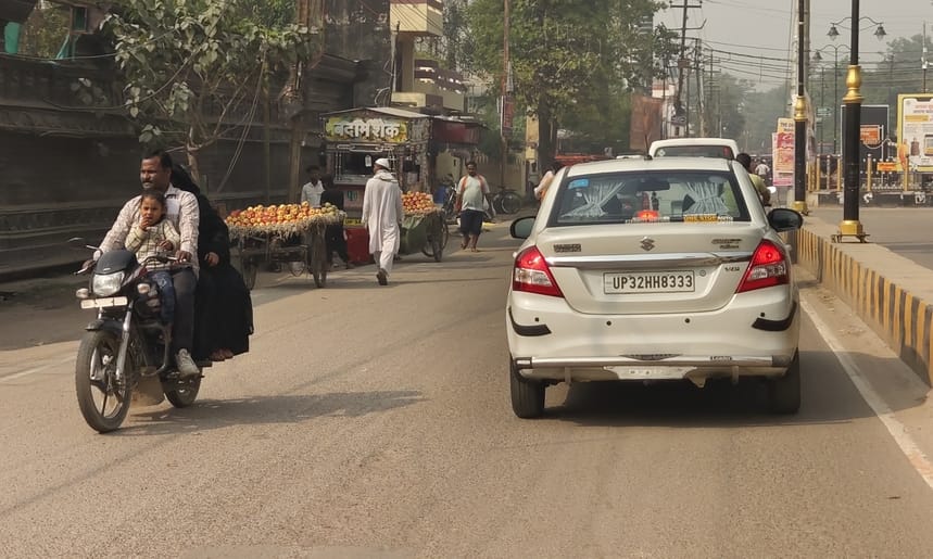 आंबेडकर पार्क के पास परिवार को बैठकर हेलमेट हैंडल में टांगकर जाते बाइक सवार। संवाद