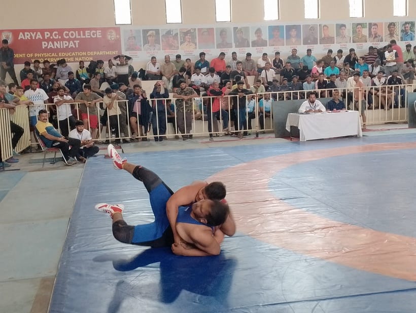 राष्ट्रीय कुश्ती प्रतियोगिता में पहलवानों का हाथ मिलवाकर कुश्ती शुरू कराते जिला शिक्षा अधिकार