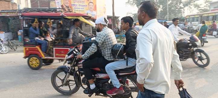 कांट में हाथ में हेलमेट लेकर जाता बाइक में पीछे बैठा युवक। संवाद