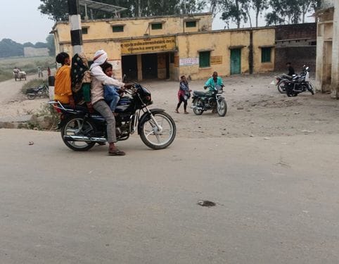 तीन सवारी बिना हेलमेट जाते स्कूटी सवार युवा। संवाद तीन सवारी बिना हेलमेट जाते स्कूटी सवार युवा। संवाद