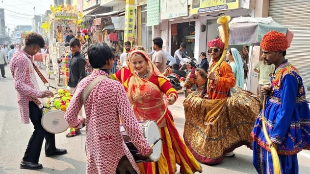 उझानी में पंचकल्याणक महोत्सव में शोभायात्रा में शामिल अनुयाइयों पर फूल बरसाते पूर्व मंत्री और व