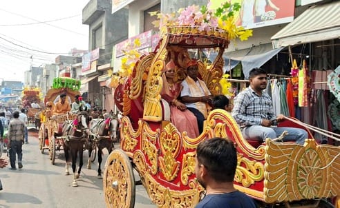 उझानी में पंचकल्याणक महोत्सव में शोभायात्रा में शामिल अनुयाइयों पर फूल बरसाते पूर्व मंत्री और व