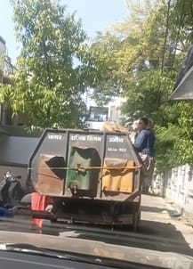 कचरा गाड़ी पर बिना सुरक्षा के बैठी महिला कचरा गाड़ी पर बिना सुरक्षा के बैठी महिला