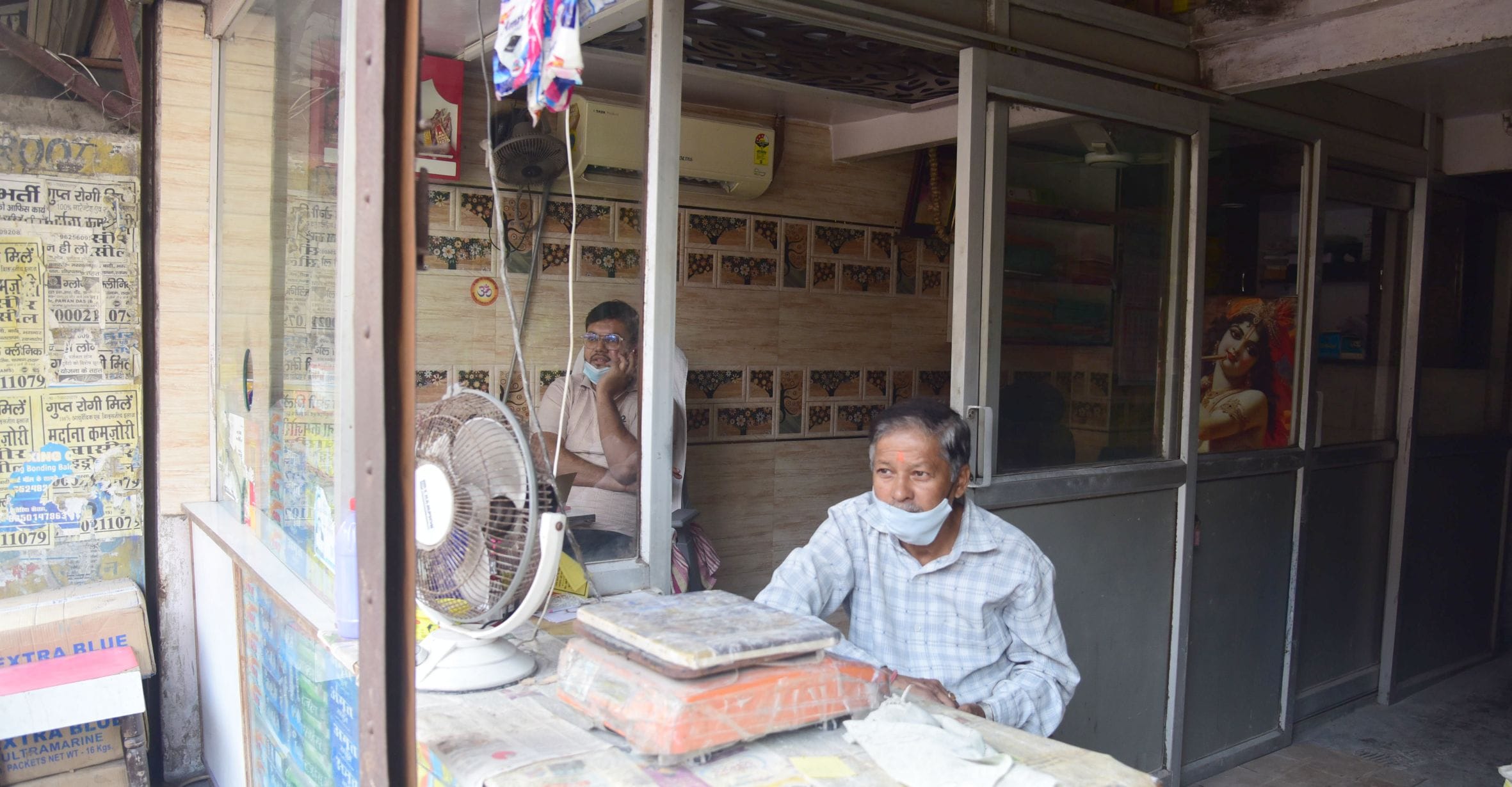 मोबाइल टॉर्च की रोशनी में काम करता दुकानदार और दुकान में सन्नाटा। मोबाइल टॉर्च की रोशनी में काम करता दुकानदार और दुकान में सन्नाटा।