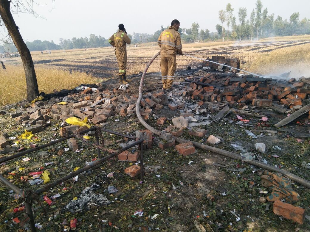 नगराम-अब्बास नगर मार्ग पर स्थित पटाखा गोदाम और आसपास खेत में लगी आग को बुझाते दमकल व पुलिसक
