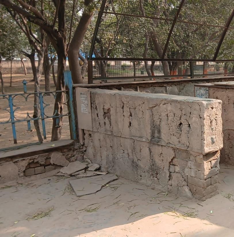 नेहरू पार्क के बाहर झुका हुआ बोर्ड नीचे पड़ा कर्कट। संवाद