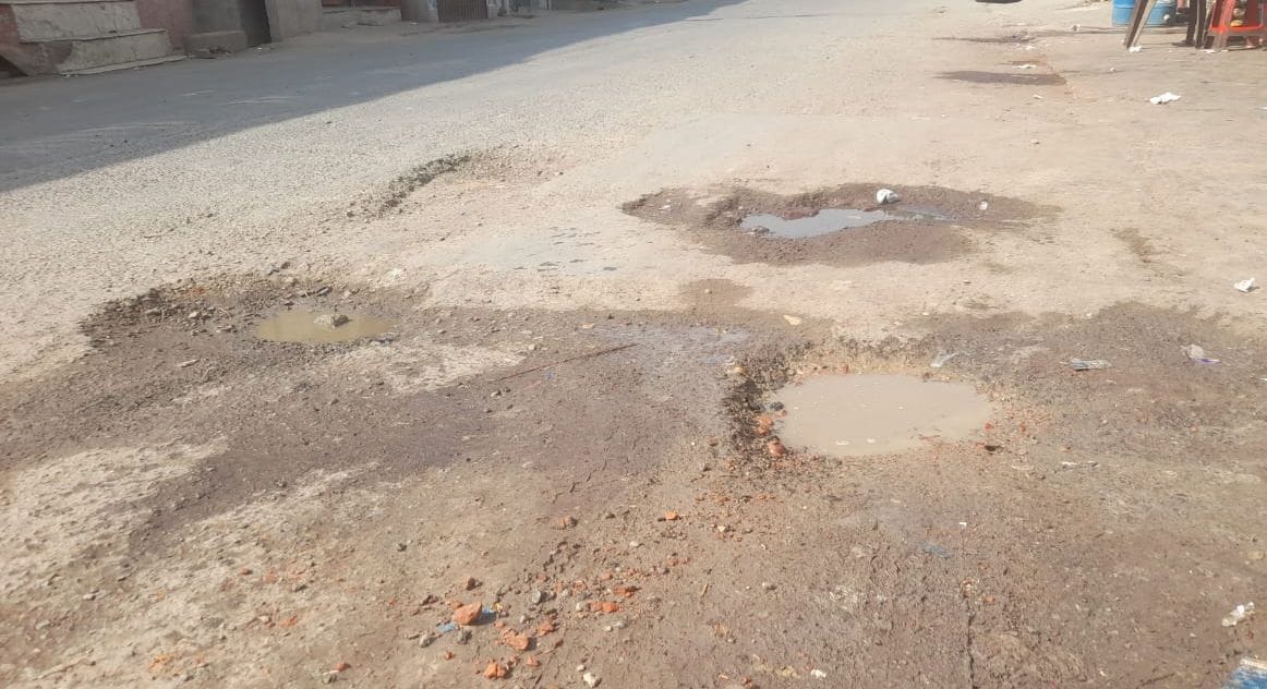 बहादुरगंज जेल रोड पर सड़क उखड़ने से हुआ गड्ढा। संवाद