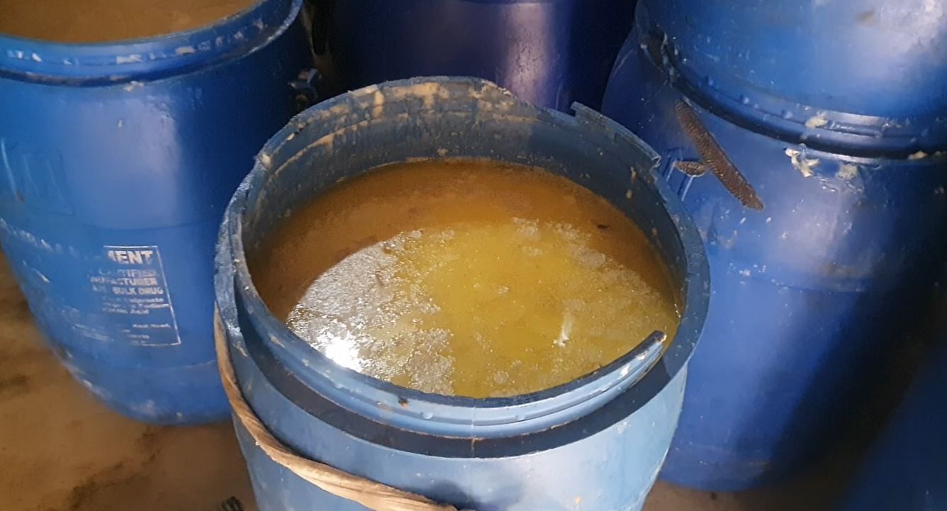 53पनीर को नष्ट करने के लिए ले जाते कर्मचारी।