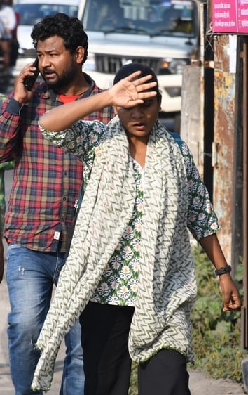 मंगलवार को तीखी धूप के कारण जैकेट उतार कर जाते लोग। 