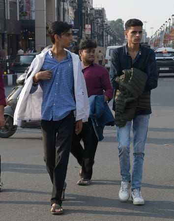 मंगलवार को तीखी धूप के कारण जैकेट उतार कर जाते लोग। 